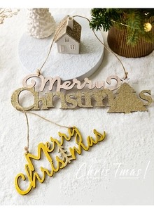 Détail des plaques Merry Christmas en paillettes dorées et bois sur fond de neige festif