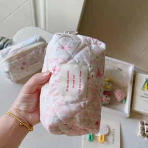 Vue détaillée d'une trousse de maquillage matelassée à fleurs et texture souple