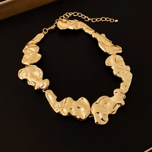 Détail du collier doré style lave avec pièces en métal fondu et fermoir mousqueton