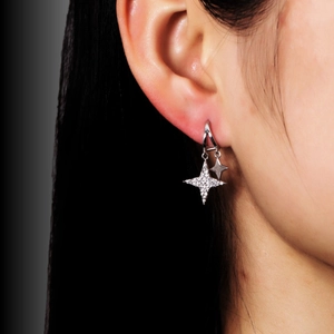 Close-up of dangling star earrings with cubic zirconia stones on model ear