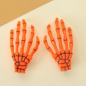 Close-up of bright orange skeleton hand hair clips with detailed black bone joints