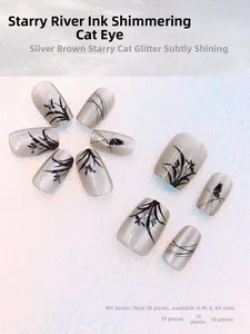 Macro view of 30-piece silver-brown cat eye press-on nails with black ink orchid patterns