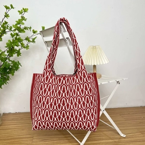 Detailed close-up of the red and white geometric wave knit texture on a large tote bag