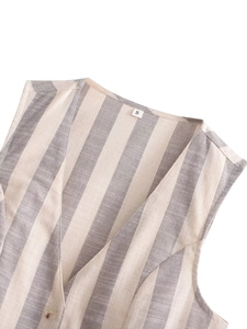 Gros plan détaillé du gilet en lin rayé à col en V montrant la texture et les coutures