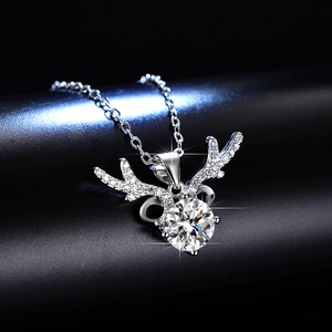 Macro detail of silver reindeer pendant featuring a brilliant round moissanite stone