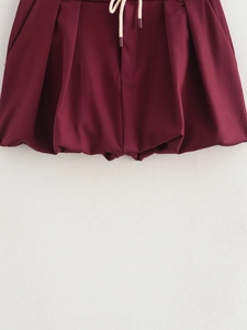 Detail of burgundy drawstring shorts with ruched elastic waistband and pleats