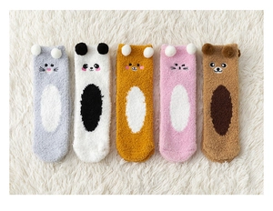Flat lay of five pairs of thick coral fleece winter socks with cute animal faces