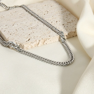Classic 6mm silver stainless steel Cuban link chain necklace on textured stone