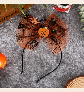 Close-up of Halloween headband with orange mesh pumpkin and spider web bow details