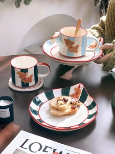 Detail of ceramic coffee mugs with 3D dog relief and colorful stripes in a cozy cafe