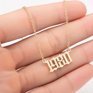Detailed close-up of 1980 gold gothic number pendant necklace held in hand