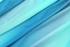 Dettaglio di strati di tessuto a rete multicolore con texture in garza blu e azzurra