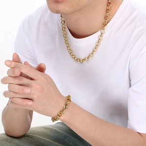 Close-up of minimalist gold titanium steel chain necklace and bracelet set on a male model