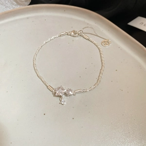 Primo piano di un bracciale in argento con ciondoli a stella in zircone su vassoio