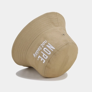 Khaki cotton bucket hat featuring white NOPE embroidery against a clean grey background