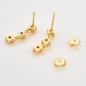Macro detail of S925 silver gold-plated earrings with orange and green zircon stones