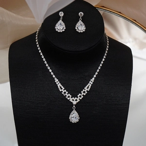 Detail of silver bridal jewelry set featuring sparkling teardrop crystals on a necklace