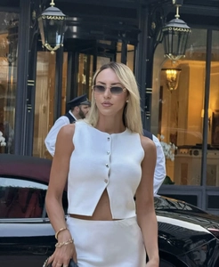 Détail du haut tricoté sans manches à boutons blanc dans un décor de style de vie luxueux