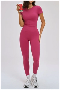 Full body shot of a woman in rose red high-stretch yoga set with crop top and leggings