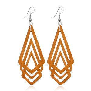 Détail de boucles d'oreilles géométriques en bois avec crochets argentés élégants