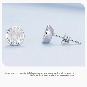 Macro shot of silver round-cut cubic zirconia stud earrings with bezel setting detail