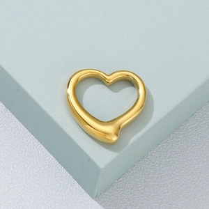 Macro shot of polished gold hollow heart-shaped stainless steel pendant jewelry accessory
