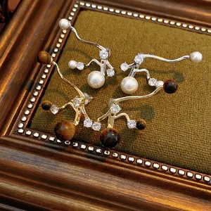 Artistic twig earrings with tiger eye, pearls, and zircons in silver and gold finish