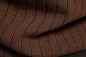 Macro shot of high-quality brown and black striped knit fabric with ribbed texture