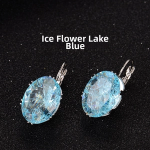 Detailed close-up of ice flower lake blue oval faceted earrings with claw settings