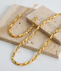 Detail of gold-plated baroque necklace with textured oval links and lobster clasp