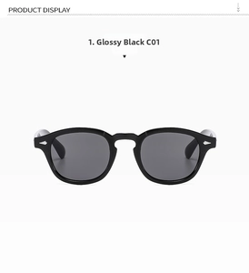 Macro view of bright black oval frames with silver rivets and grey tinted lenses