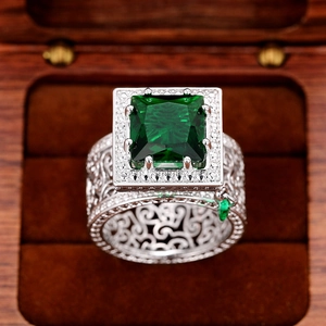 Macro shot of silver ring with square green gemstone and intricate镂空engraved details
