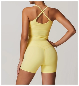 Detail of cross-back yoga tank top and high-waist shorts in bright yellow sports fabric