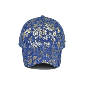 Macro detail of blue denim baseball cap featuring premium gold floral embroidery