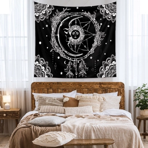 Detail of black and white bohemian sun and moon tapestry used as bedroom wall decoration