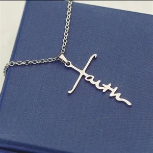 Silver stainless steel cross necklace featuring faith pendant on navy jewelry box