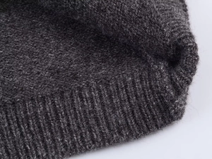 Macro shot of dark grey knit fabric showing detailed thick rib texture and wool softness