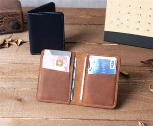Brown and blue crazy horse leather card holders displayed on a vintage wooden desk setup