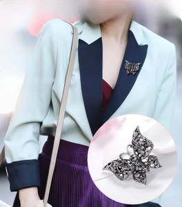Detail of vintage butterfly brooch with black crystals on a light suit lapel