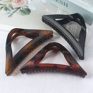 Three elegant triangular hair clips in matte black and tortoiseshell amber patterns