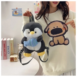 Detail of cute plush penguin backpack with blue fish being worn by a model in a home setting