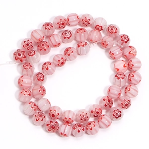 Macro shot of pink millefiori glass beads with red floral patterns and stripes