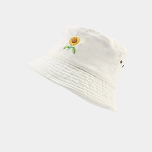 Détail de la broderie tournesol et de l'œillet sur un chapeau bob en coton blanc