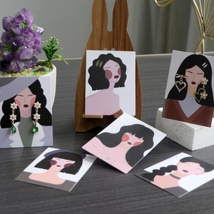 Detail of jewelry display cards with cartoon goddess illustrations and earrings