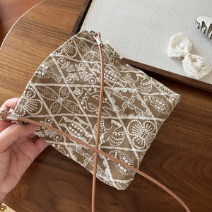 Close-up of vintage embroidered canvas bag with leather strap and floral patterns