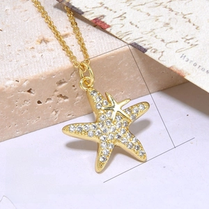 Detailed view of starfish pendant with white cubic zirconia and 18k gold plating