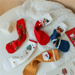 Détail de chaussettes de Noël douces avec motifs cerf et père Noël sur polaire