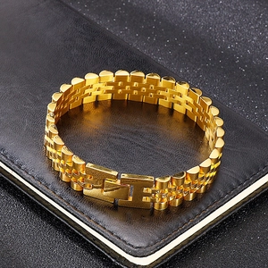 Detailed macro view of the golden watch-strap style steel bracelet on black leather texture