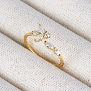 Detail of 18K gold adjustable ring with marquise and round cut shimmering cubic zirconia