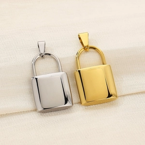 Detailed close-up of gold and silver polished stainless steel lock pendants on fabric